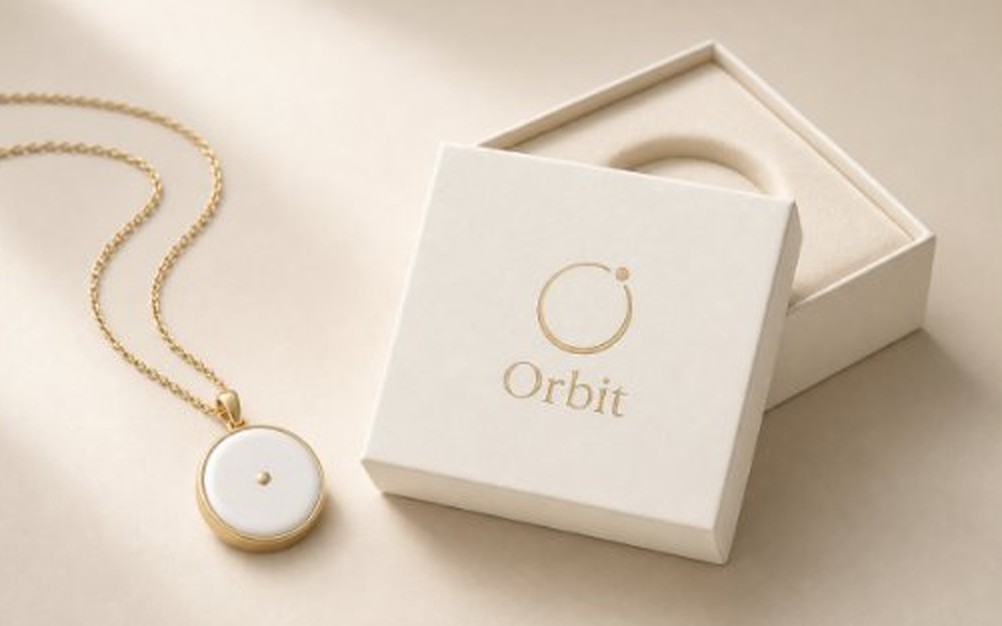Orbit pendant in porcelain and gold next to its gift box